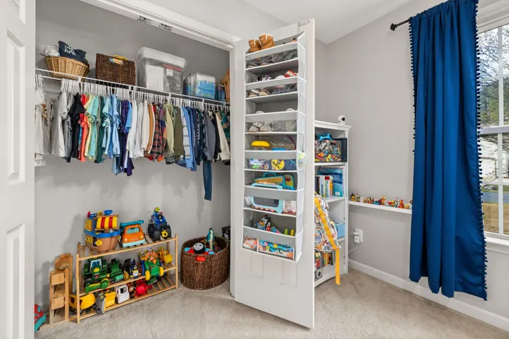 A child's closet with clothes and toys put in order